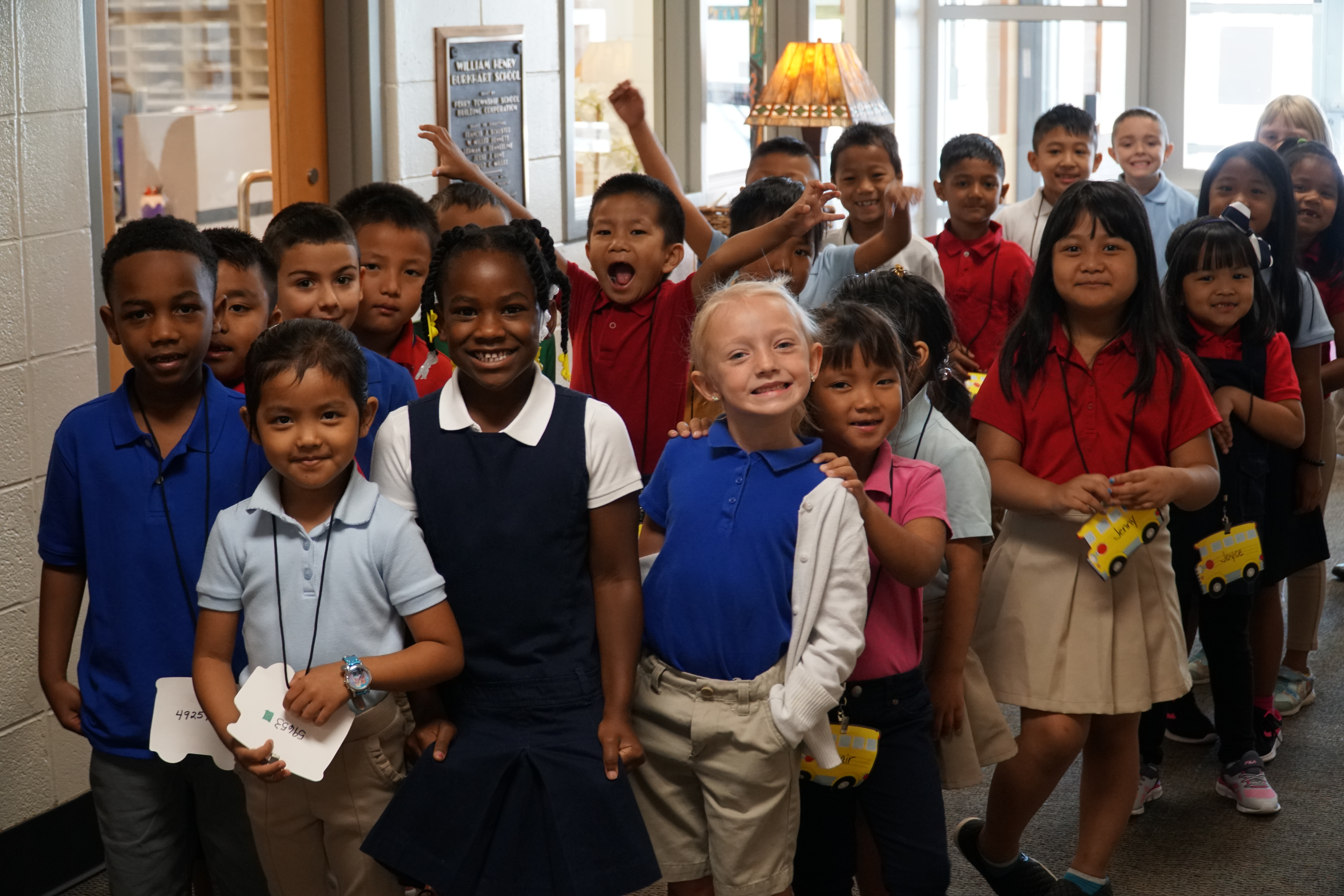 Group of elementary students smiling in a school hallway