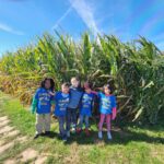 Students standing in front of tall corn stalks