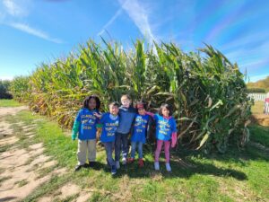 Students standing in front of tall corn stalks
