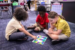 students playing an original board game they designed.