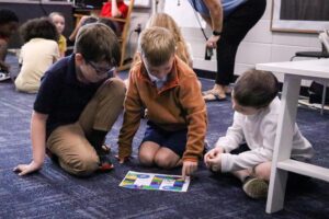 students playing an original board game they designed.