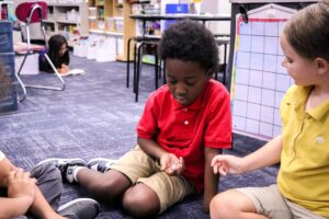 students playing an original board game they designed.