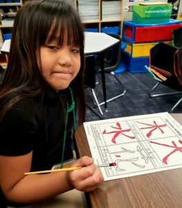 Students painting Japanese characters