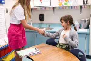 first grade student shaking hands with Mrs. White