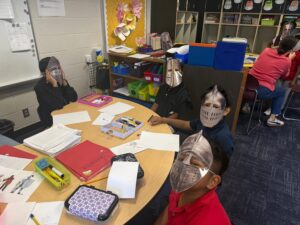 4th grade students sitting around a table dressed as serfs and knights of the Middle Ages