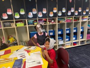 4th grade students sitting around a table dressed as serfs and knights of the Middle Ages