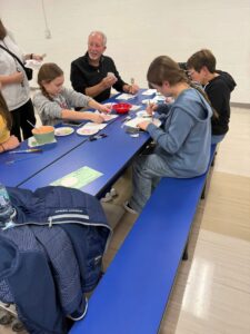 students and families painting ornaments
