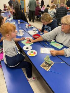 students and families painting ornaments