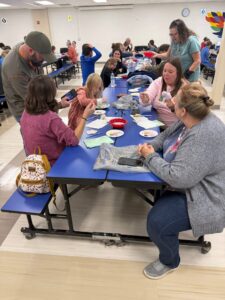 students and families painting ornaments