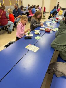 students and families painting ornaments