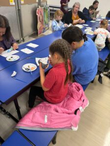 students and families painting ornaments