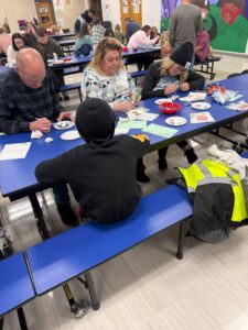 students and families painting ornaments