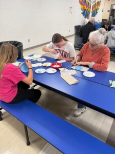 students and families painting ornaments