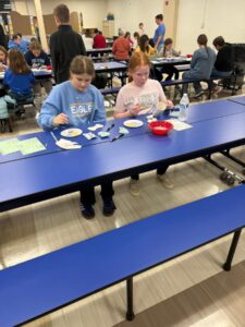students and families painting ornaments