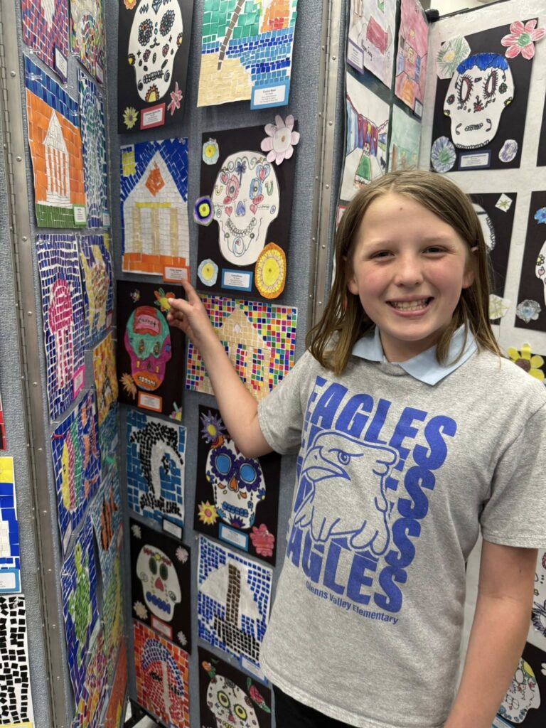 Student pointing to her Greek mosaic