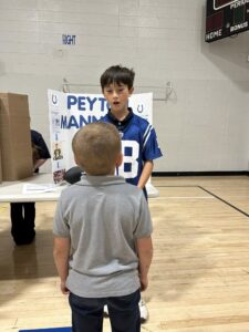 Student dressed as Peyton Manning and presenting at the wax museum