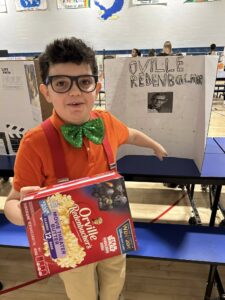 Student dressed as Orville Redenbacher and presenting at the wax museum