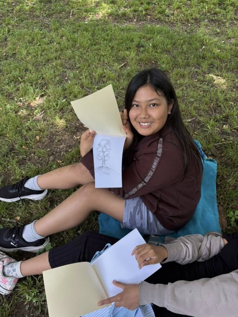 Students using charcoal sticks to draw and write in their Civil War camp journals