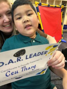 photo a first grade student holding his Soaring eagle certificate