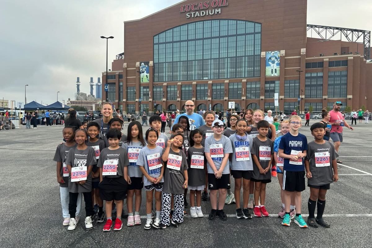 a rendering of the Glenns Valley running club standing in front of Lucas Oil Stadium with their coaches Mrs. Beard and Mr. wood