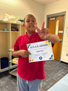 photo a fifth grade student holding his Soaring eagle certificate