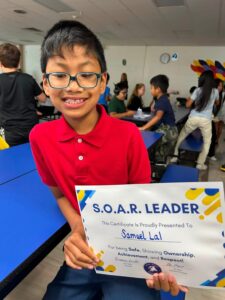 photo a fourth grade student holding his Soaring eagle certificate