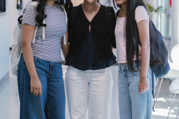 Three Perry Township Schools students stand together in a hallway on the University of Indianapolis campus during filming for the Innovation & Entrepreneurship Program.