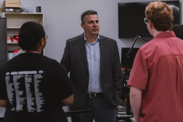The director of Perry Township Schools' Innovation & Entrepreneurship Program speaks with students during a collaborative learning activity.